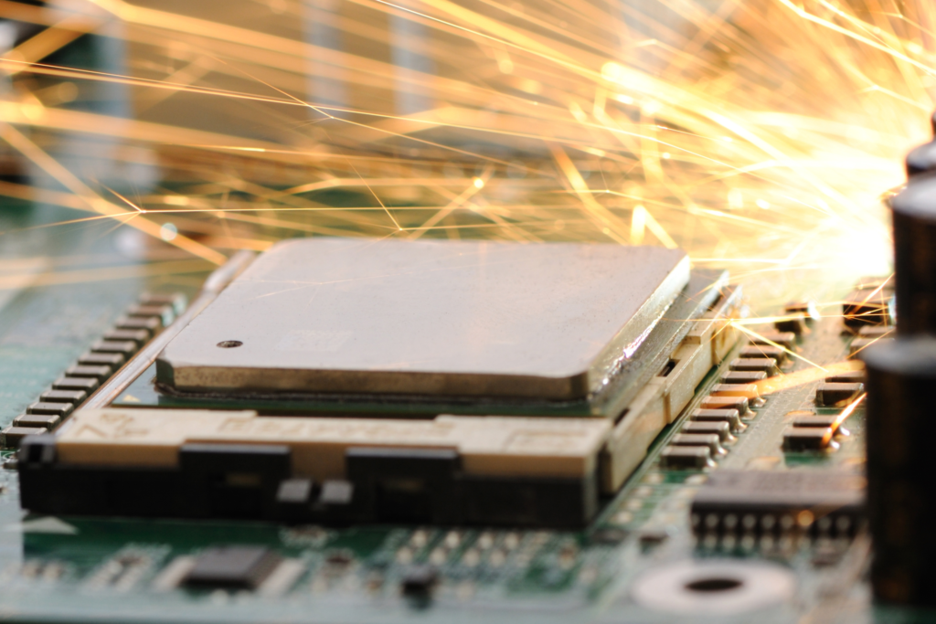 A malfunctioning computer motherboard with sparks in the background