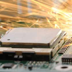 A malfunctioning computer motherboard with sparks in the background