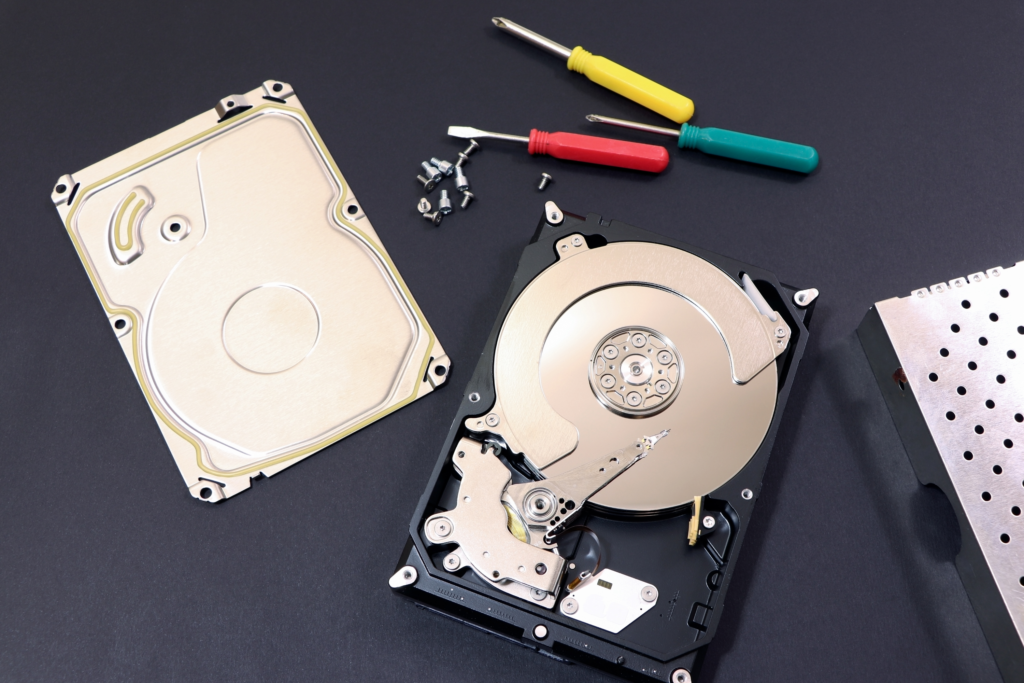 A dismantled hard drive, showing its screws and cover