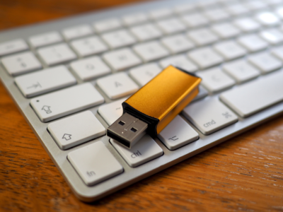 A USB stick on top pf a mac computer keyboard