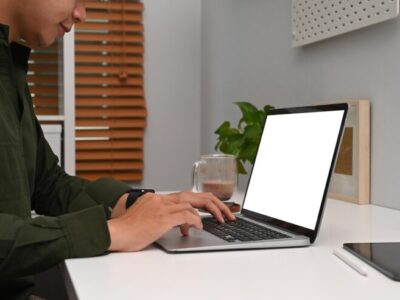 A business owner working on his Macbook while drinking coffee