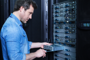 A man using the screw to the part of the server