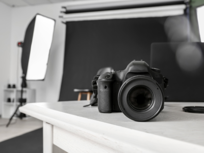 A camera on a table, and a small photo studio in the background